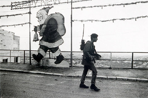 Bethlehem, 1987.Israeli patrol soldier passing New Year and Christmas decorations.